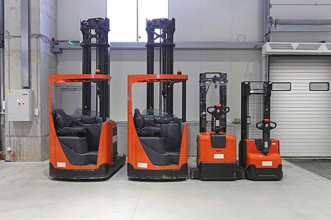 forklift operator moving large crates in a storage facility